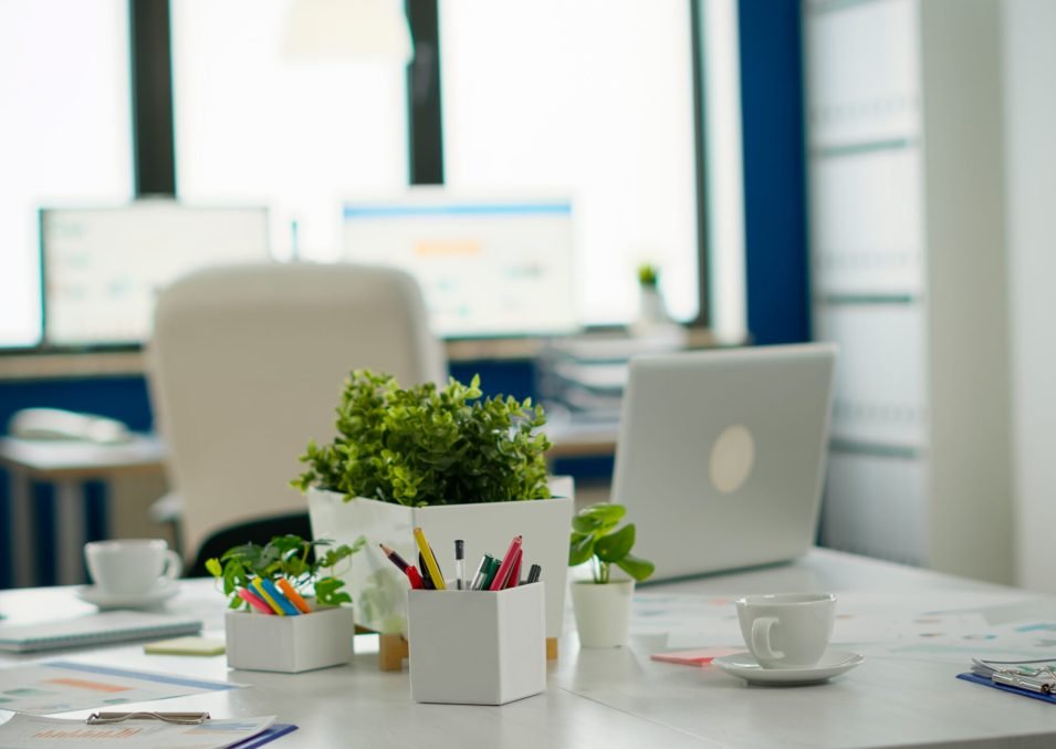 Modern business meeting zone interior with conference table and white chair. Brainstorm area in business center with nobody in it, shot of empty room with modern furniture, white shelves and blue wall